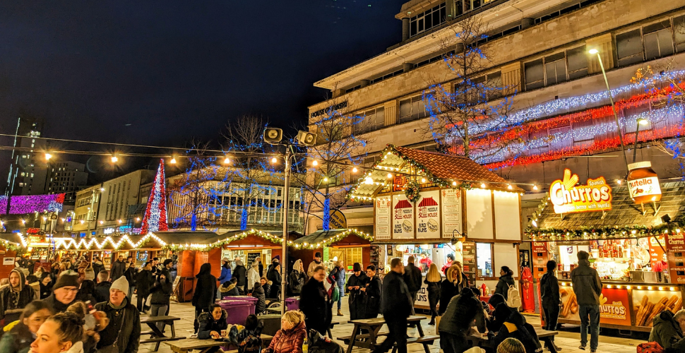 Plymouth Christmas Market with people in the foreground and stalls in the background